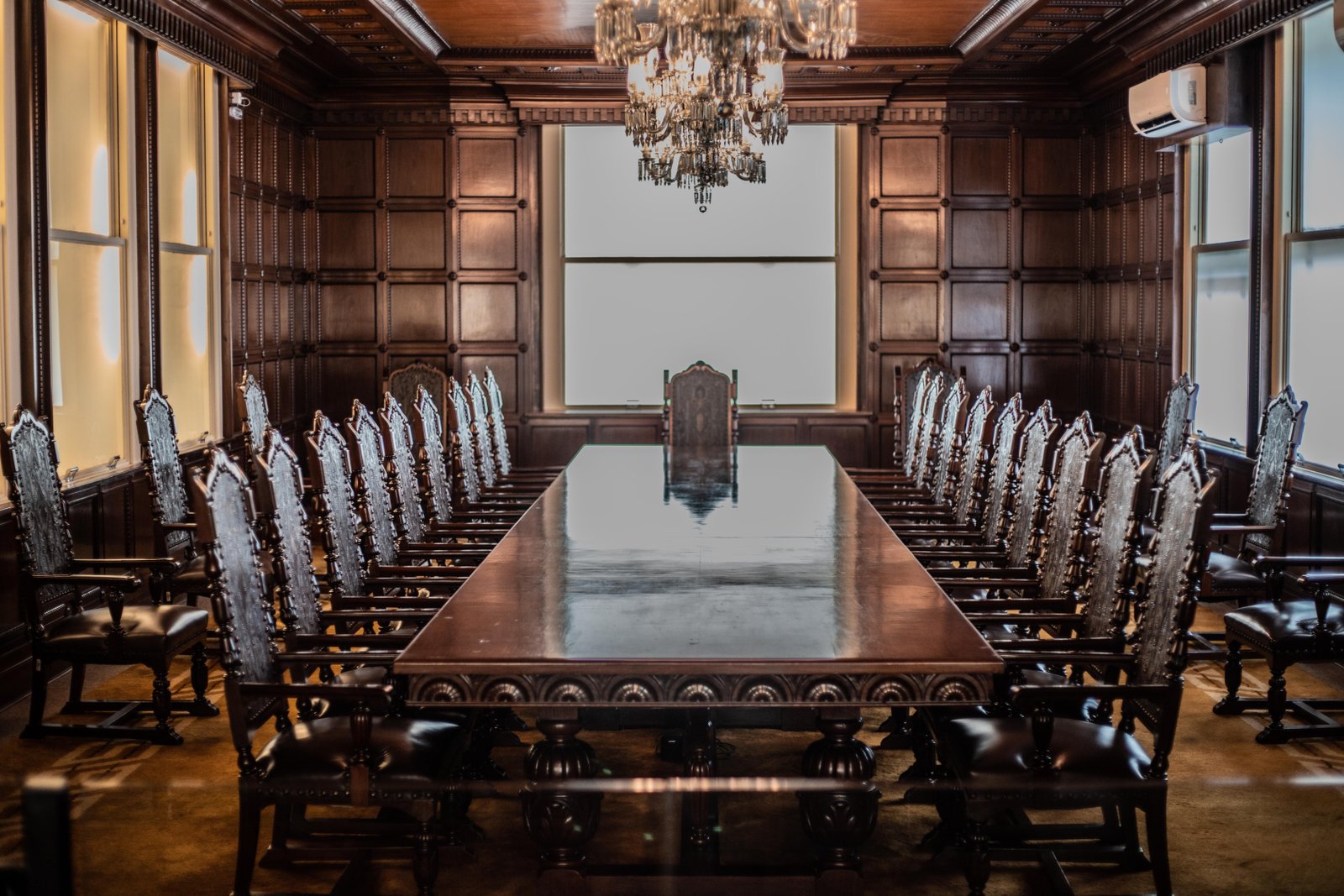 a large conference room with a chandelier hanging from the ceiling